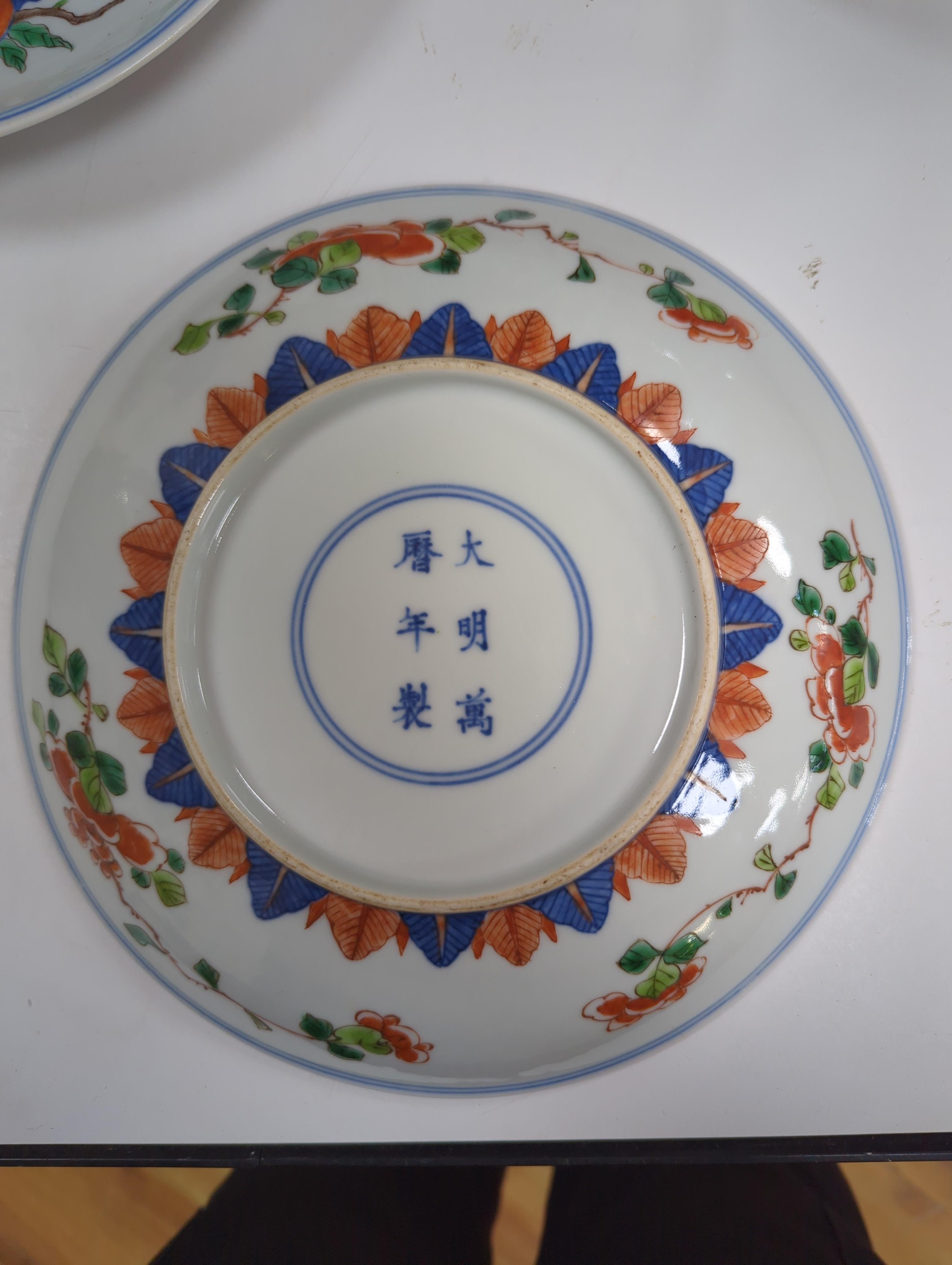 An 18th century Chinese famille rose bowl and a group of five Chinese wucai plates, each decorated with fruit, the bowl 23cm in diameter